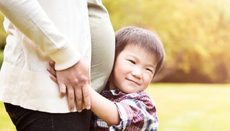 pregnant mother with children. Maternity insurance to protect newborn