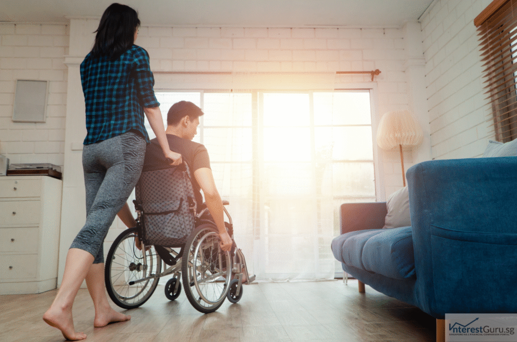 Caregiver supporting a man in a wheelchair at home, symbolising the importance of CareShield Life and supplement plans in providing long-term care coverage in Singapore.